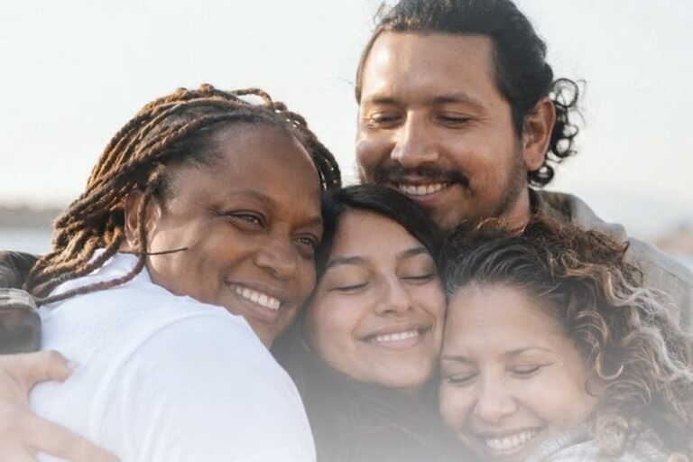 Cuatro personas se abrazan sonriendo